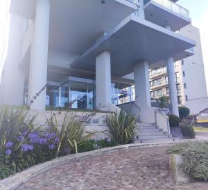 a building with white columns and purple flowers at Excelente Vista al Golf y al Mar in Mar del Plata