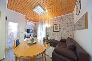 a living room with a table and a couch at Apartments with a parking space Postira, Brac - 22159 in Postira +9 photos