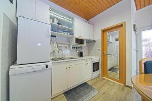a white kitchen with a sink and a refrigerator at Apartments with a parking space Postira, Brac - 22159 in Postira
