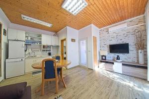 a kitchen and dining room with a table and a tv at Apartments with a parking space Postira, Brac - 22159 in Postira