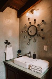 La salle de bains est pourvue d'un lavabo et d'une horloge murale. dans l'établissement Bärehuus Boutique Hotel, à Antigua Guatemala
