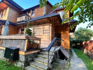 a wooden house with stairs in front of it at Willa Jasna Apartamenty centrum Zakopane in Zakopane