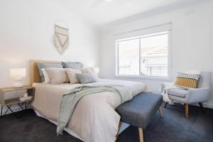 a bedroom with a bed and a chair and a window at By the Bay - 100m to Beach in Rosebud