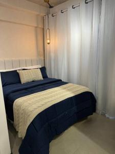 Un dormitorio con una cama azul y blanca con cortinas en Jardins São Paulo, en São Paulo