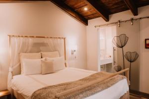 a bedroom with a large white bed with white pillows at Bärehuus Boutique Hotel in Antigua Guatemala