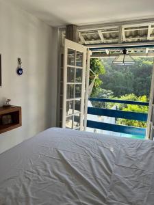 a bedroom with a bed and a large window at Casa Cristo Redentor c/piscina in Rio de Janeiro