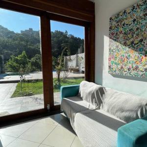 a living room with a couch and a large window at Casa Cristo Redentor c/piscina in Rio de Janeiro