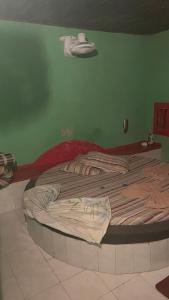 uma cama grande num quarto com uma parede verde em Motel Casarão em Osório