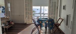 a table and two chairs in a room with a window at Tambo Bombinhas in Bombinhas