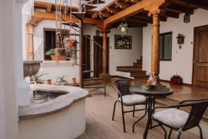 a living room with a table and chairs and a tub at Bärehuus Boutique Hotel in Antigua Guatemala