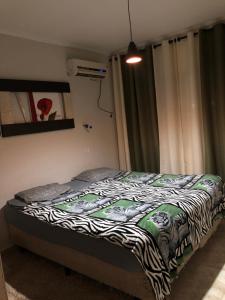 a bedroom with a bed with a zebra print blanket at Quarto Duplo Costa brava in Guarujá