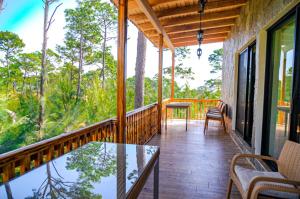 a balcony of a house with a table and chairs at La Ocotera Hotel De Montaña in San Marcos