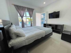 1 dormitorio con 1 cama grande y TV en Rio Hotel lagos en Leticia