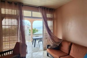 - un salon avec un canapé et une grande fenêtre dans l'établissement Vaiana Home 2 - bord de lagon, à Taputapuapea