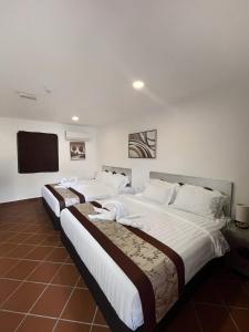 two beds in a hotel room with a flat screen tv at Mclane Boutique Hotel in George Town