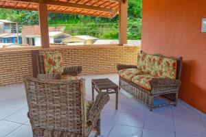a patio with two chairs and a table and a chair and a chair at Ap Standart - Pousada Flor da Serra - Mulungu in Mulungu