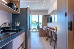 Una cocina con fregadero y una mesa con sillas. en Makia114experience, en Porto de Galinhas