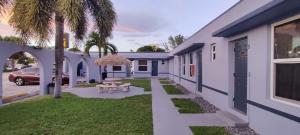 ein Haus mit einer Palme im Hof in der Unterkunft Crown Inn in Fort Lauderdale