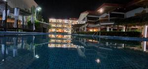 uma piscina em frente a um hotel à noite em Jaco Laguna Resort & Beach Club em Jacó