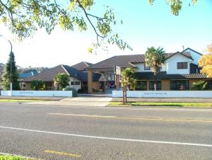 ein Haus am Straßenrand mit einer Straße in der Unterkunft Palm City Motor Inn in Napier