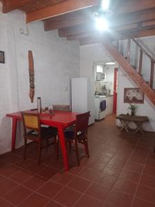 uma mesa vermelha e cadeiras num quarto com uma cozinha em Alojamiento por día Merlo San Luis em Merlo