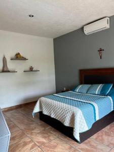 - une chambre dotée d'un lit avec une croix sur le mur dans l'établissement Quinta Eloísa, à Cuernavaca