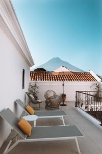 a patio with a table and chairs on a roof at Bärehuus Boutique Hotel in Antigua Guatemala