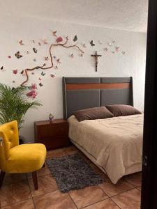 - une chambre avec un lit et une croix sur le mur dans l'établissement Quinta Eloísa, à Cuernavaca