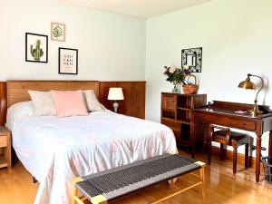 ein Schlafzimmer mit einem Bett, einem Schreibtisch und einem Klavier in der Unterkunft COIS FARRAIGE BESIDE The SEA in North Rustico