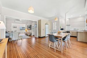 a kitchen and dining room with a table and chairs at Narooma Lighthouse Cottage - 74 Princes Highway Narooma in Narooma