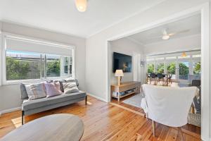 a living room with a couch and a table at Narooma Lighthouse Cottage - 74 Princes Highway Narooma in Narooma +15 photos