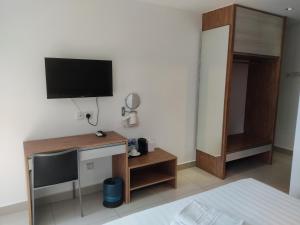 a bedroom with a tv on a wall with a bed at Jin Hotel in Puchong