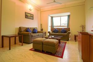 een woonkamer met 2 banken en een tafel bij OYO 6825 New Crescent Citadel in Bangalore