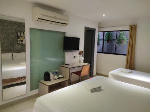 a hotel room with two beds and a television at Jin Hotel in Puchong