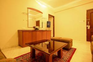 een woonkamer met een salontafel en een spiegel bij OYO 6825 New Crescent Citadel in Bangalore