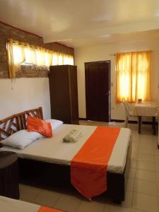 1 dormitorio con 1 cama con sábanas de naranja y naranja en Isla Bonita Beach Resort, en San Juan