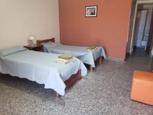 two beds in a room with two tables at Casa Alfonso I in Humahuaca