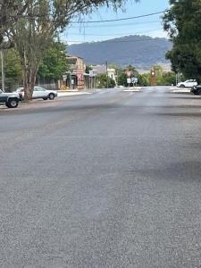 an empty street in a town with cars parked at A Homestead on Market in Mudgee