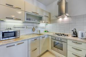 eine Küche mit einer Spüle und einer Mikrowelle in der Unterkunft Apartment Dea - Three Bedroom Apartment in Pula