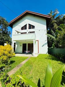 a white house with a lawn in front of it at Haus Berlin in Negombo