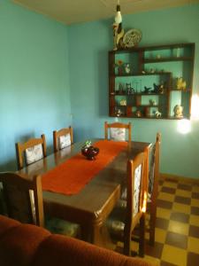 a dining room with a wooden table and chairs at Arcoiris in La Coronilla