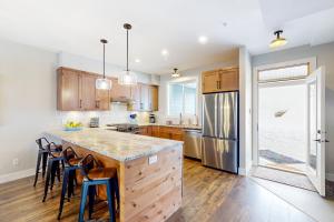 a kitchen with wooden cabinets and a large island with bar stools at Bear Cave- Grizzly Ridge 260A in Big White
