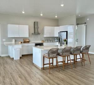 uma cozinha com armários brancos e uma mesa e cadeiras em Canyon Oasis suite with Grand Mesa view em Big Water