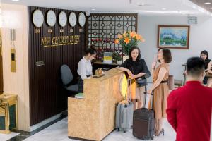 a group of people standing at a counter with luggage at New Century Hotel Cau Giay in Hanoi