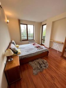 1 dormitorio con 1 cama grande y suelo de madera en 1-bedroom deluxe condo in Pamporovo, en Pamporovo