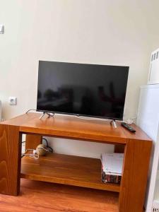 TV de pantalla plana con soporte de madera en 1-bedroom deluxe condo in Pamporovo, en Pamporovo