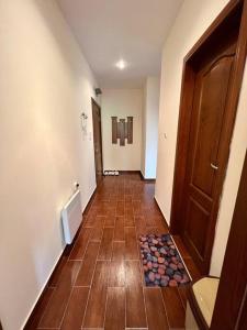 pasillo con puerta de madera y suelo de baldosa en 1-bedroom deluxe condo in Pamporovo, en Pamporovo