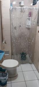 uma casa de banho com um WC e um chuveiro com uma cortina de chuveiro em Kitnet 500 M da praia na Praia Grande