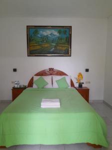 a bedroom with a green bed with a picture on the wall at Jiva Bungalow in Nusa Lembongan +21 photos