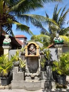a statue in a fountain in front of a house at Jiva Bungalow in Nusa Lembongan